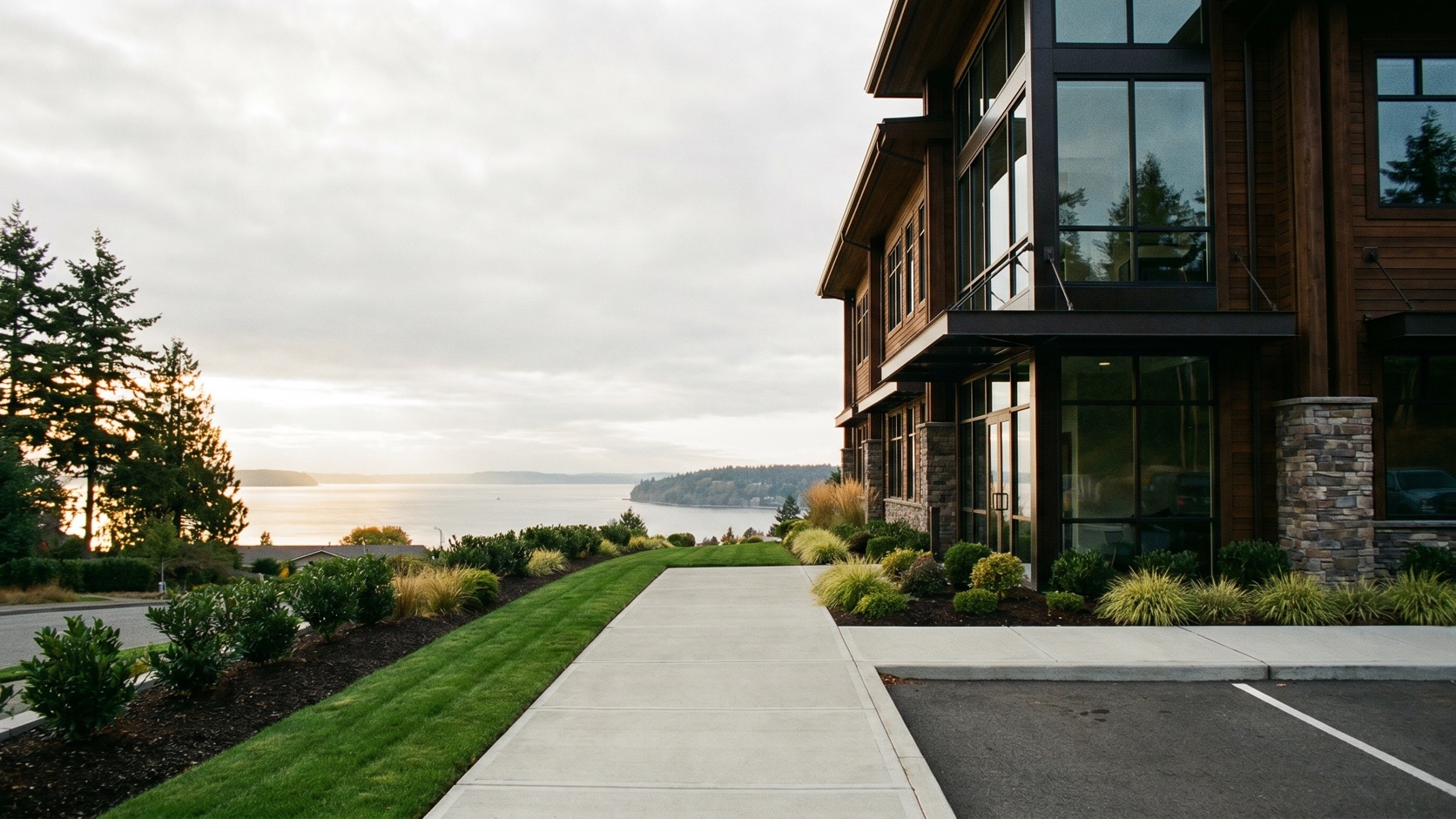 Clean modern commercial building exterior with fresh landscaping at dusk overlooking Puget Sound near Sunset Hill